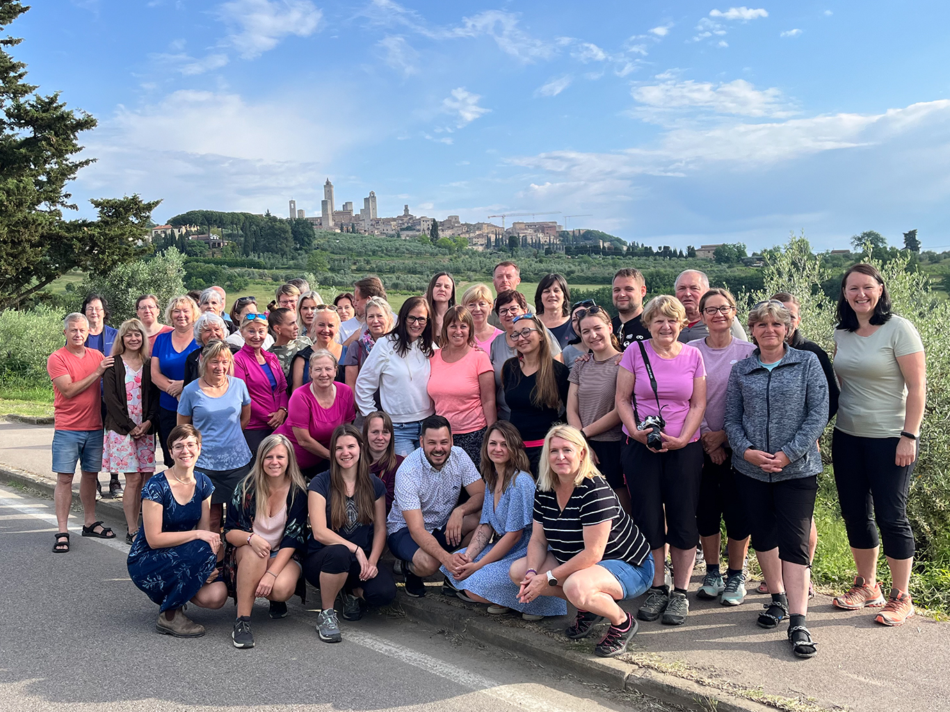 Skupinové foto s typickými vinicemi a městečkem San Gimignano