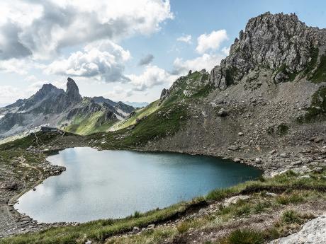 Horské jezero Lac de Presset v pozadí se skalním zubem Pierra Menta